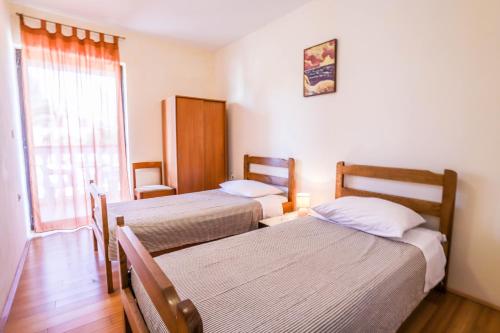 ein Hotelzimmer mit zwei Betten und einem Fenster in der Unterkunft Medulin Riviera Apartments Goran in Medulin
