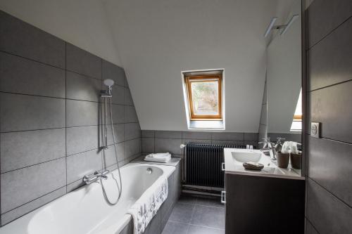 a bathroom with a bath tub and a sink at La haut in Saverne