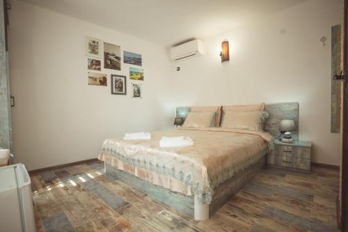 um quarto com uma cama grande e uma parede branca em The Greek House em Ahtopol