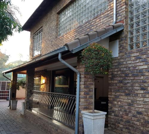 awning on the side of a brick building with a bench at Falling Feather Inn in Pretoria