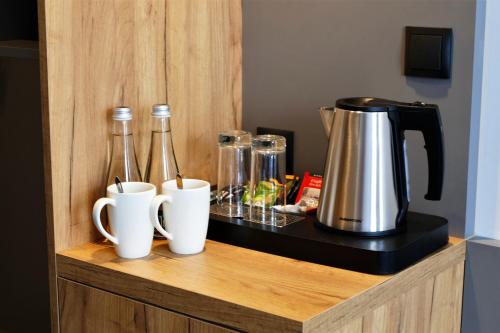 a counter with two coffee makers and two cups on it at Hotel Mokotów in Warsaw