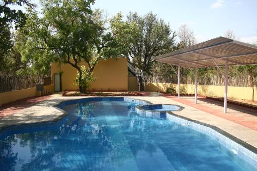 una piscina en un patio con un pabellón en Baaz Jungle Resort, en Khawāsa