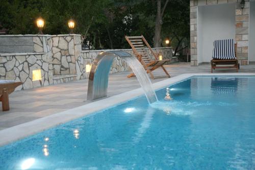 a swimming pool with a water fountain in a yard at Villa Katarina in Tivat