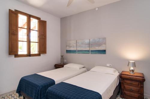 two beds in a room with two windows at Villa Valls in Montuiri