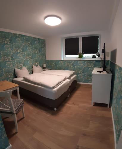 a bedroom with a bed and a table and a window at Pension Altes Forstamt in Eberswalde-Finow