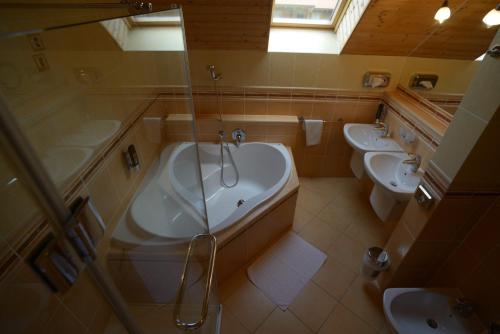 a bathroom with two sinks and a tub and two toilets at Zrubové chaty Stará Lesná in Stará Lesná