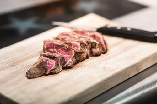 a piece of steak on a wooden cutting board at Anthony's Life&Style Hotel in Sankt Anton am Arlberg