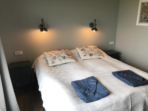 een slaapkamer met een bed met handdoeken erop bij Loa's Nest in Hella