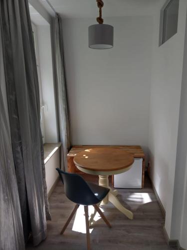 a small table and a chair in a room at Gästehaus Twee Linden in Warnemünde