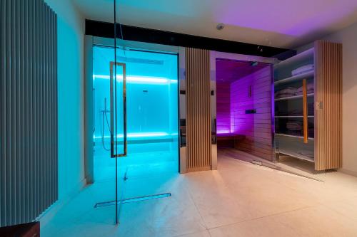 a room with a glass door with purple and blue lights at Ilonn Hotel in Poznań