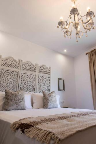 a bedroom with a large bed with a chandelier at Hostal Boutique Olvido 22 Adults Only in Peñíscola