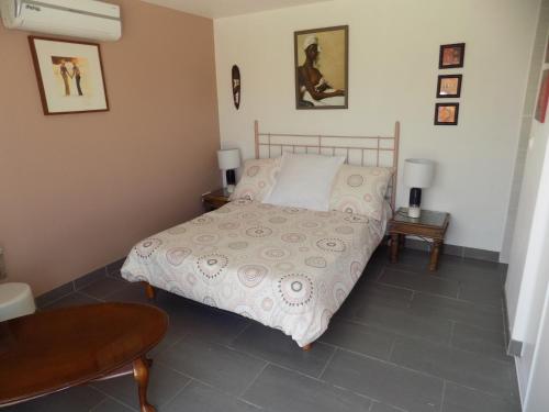a bedroom with a bed and a table at Villa VAYA in Villemoustaussou