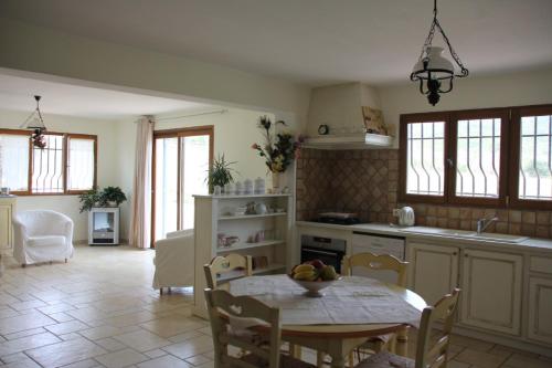 une cuisine avec une table, des chaises et une table ainsi qu'une salle à manger dans l'établissement Domaine de la Marie dans le Luberon, à Peypin-dʼAigues