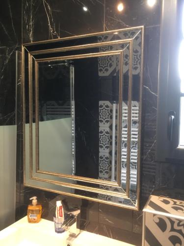 a mirror over a sink in a bathroom at CUGNAUX Toulouse Metropole OUEST Chambre Privée de Luxe - SDB WC privée Terrasse Piscine Aqua Bike in Cugnaux