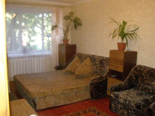 ein Wohnzimmer mit einem Sofa und einem Stuhl in der Unterkunft квартира біля лікарні мечнікова in Dnipro