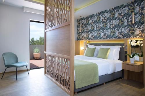 a hotel room with a bed and a chair at Dolce by Wyndham Athens Attica Riviera in Vravrona