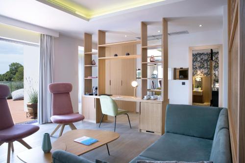 a living room with a couch and chairs and a desk at Dolce by Wyndham Athens Attica Riviera in Vravrona