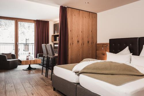 a bedroom with a bed and a chair and a desk at Anthony's Life&Style Hotel in Sankt Anton am Arlberg