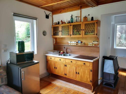 d'une cuisine avec des placards en bois, un évier et une fenêtre. dans l'établissement Florile Bucegilor, à Sinaia