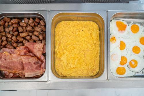 three containers of food with eggs meat and beans at Hotel Mediterraneo in Lignano Sabbiadoro