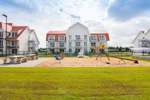a playground in a park in front of a building at Holiday Suites Nieuwpoort in Nieuwpoort