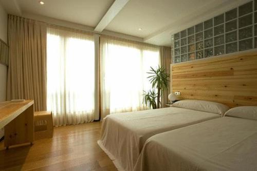 a bedroom with a large bed and large windows at La Plaza II in Luanco