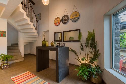a living room with a table and some plants at EL Lodge by StayVista - Pool, lawn, and a charming gazebo for your perfect getaway in Lonavala