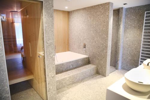 a bathroom with a bath tub and a sink at Hotel van der Valk Spier Dwingeloo in Spier