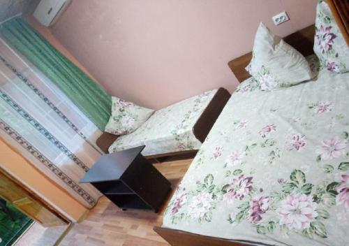 a bedroom with two beds with flowers on the sheets at Guest House U Aidy in Novy Afon