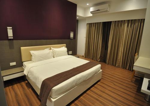 a bedroom with a large bed in a room at Tarawade Clarks Inn Pune in Pune
