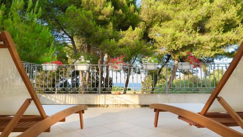 a balcony with a fence and two chairs and trees at La Dimora di Ulisse in Santa Cesarea Terme