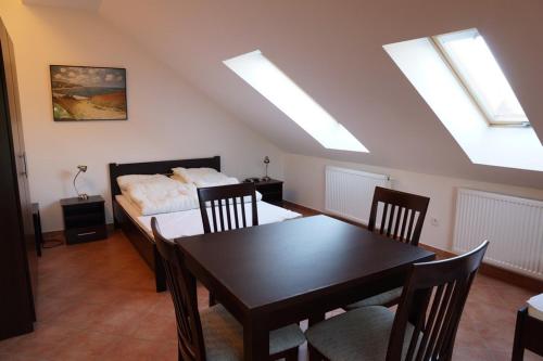 a bedroom with a table and a bed with skylights at Dom Gościnny Klemens in Dębki