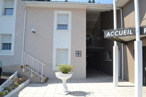 a white building with a sign in front of it at Hôtel Formules Club in Cenon