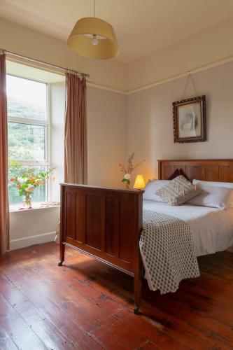 a bedroom with a large bed and a window at The Old Monastery Guesthouse in Cahersiveen