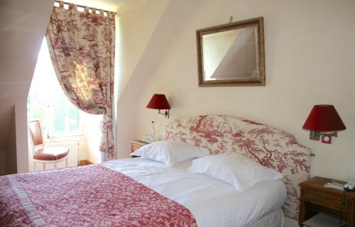 a bedroom with a bed and a mirror and a window at Château d'Ermenonville in Ermenonville