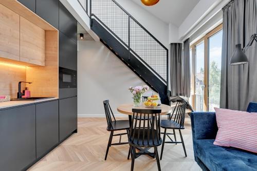 a kitchen and a dining room with a table and chairs at Pogodna Apartments in Sopot