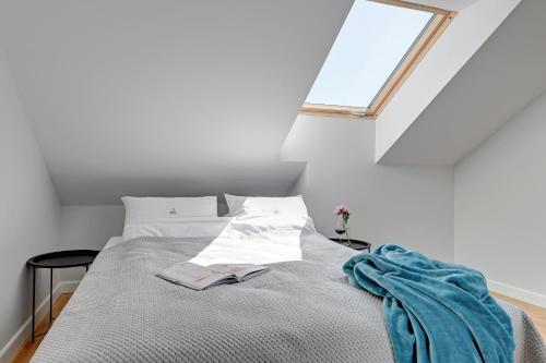 a bedroom with a bed with a window at Pogodna Apartments in Sopot