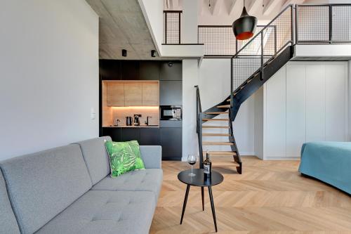 a living room with a couch and a staircase at Pogodna Apartments in Sopot