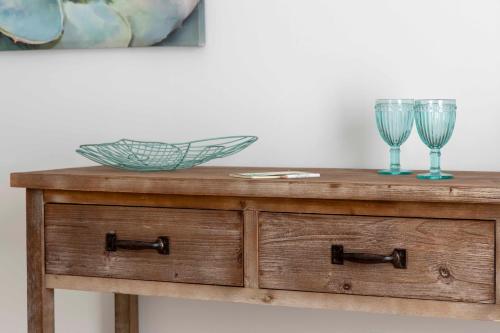 a wooden dresser with two wine glasses on it at Hostal Boutique Olvido 22 Adults Only in Peñíscola