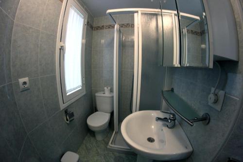 een badkamer met een wastafel, een toilet en een spiegel bij El FARO 2 in Estepona