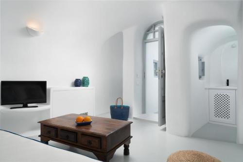 a living room with a coffee table and a tv at Oia Spirit Boutique Residences in Oia