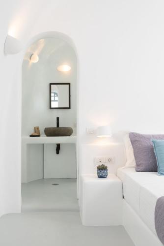 a white living room with a white couch and a sink at Oia Spirit Boutique Residences in Oia