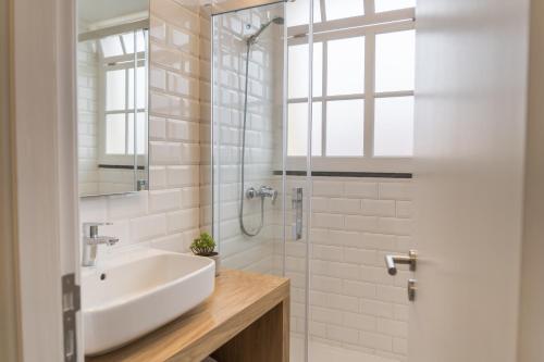 Un baño blanco con lavabo y ducha. en Funchal Village Studios, en Funchal