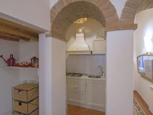 a kitchen with an archway with a sink and a stove at IL PRUNELLO - una casa tra le Torri in San Gimignano