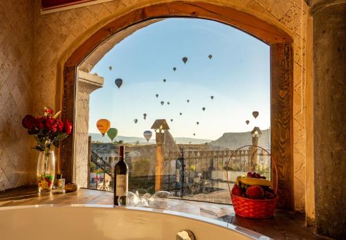 a bath tub in a room with a window with balloons at Cappadocia Inn Cave Hotel in Goreme