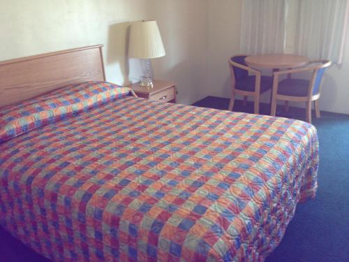 a hotel room with a bed and a table at Hacienda Motel in San Jacinto