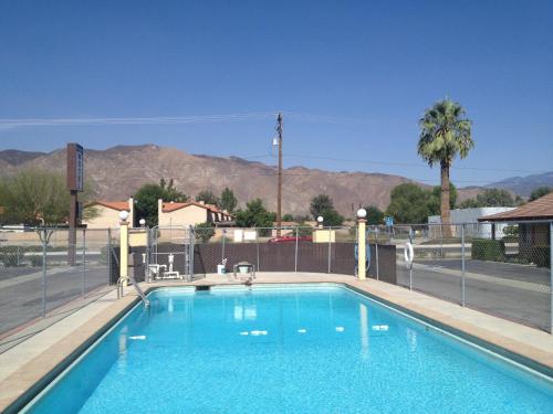 een zwembad met uitzicht op de bergen bij Hacienda Motel in San Jacinto