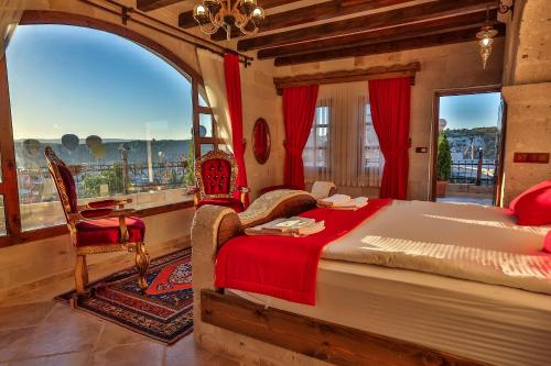 a bedroom with a large bed and a large window at Cappadocia Inn Cave Hotel in Goreme
