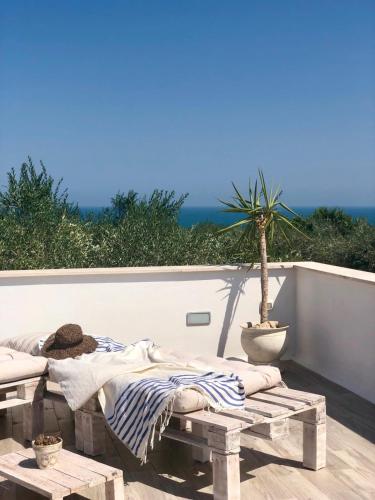 a bed on a patio with a potted plant at B&B Sperlonga in Mattinata