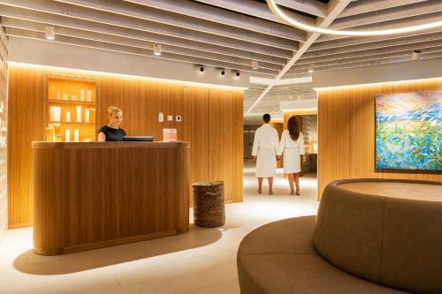 a man standing at a reception desk in a lobby at Inturotel Cala Esmeralda Beach Hotel & Spa - Adults Only in Cala d´Or